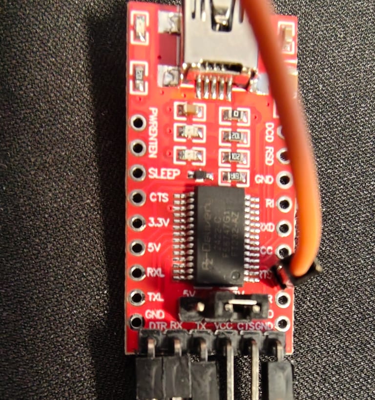 Ein roter FT232RL-USB-Seriell-Adapter mit einem orangen Jumper-Draht am RTS-Pad.